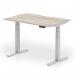 The photograph features the sleek and modern design of a Dynamic Sit Stand and Height Adjustable Desks Air in a stylish grey oak top with a silver leg. The scalloped edge adds a unique touch to the 1200 x 800mm workspace, making it a practical and versatile option for any office.