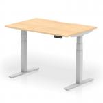 This photo captures a modern and versatile workspace, with a dynamic sit stand and height adjustable desk. The desk features a 1200 x 800mm maple top with a scalloped edge, paired with sleek silver legs. Perfect for any office setting looking for a functional and stylish desk option.