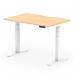 The photograph captures a modern office space with dynamic sit stand and height adjustable desks. The desks have a sleek maple top and white legs, with a scalloped edge for added style. The space is well-lit and organized, creating a productive atmosphere.
