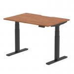 This photograph features a contemporary office desk with a walnut top and black legs. The desk is air-powered and can be adjusted to different heights, with a scalloped edge design. Its dimensions are 1200 x 800mm.