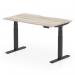 This picture shows a modern office desk with a grey oak top and black legs. It has a scalloped edge and can easily be adjusted to sit or stand at a height of 1400mm by 800mm. This ergonomic design promotes movement and adaptability, allowing for a more dynamic and comfortable workspace.