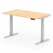 The picture shows a dynamic sit-stand desk with a scalloped edge maple top and silver legs. It is 1400 x 800mm in size and features height adjustability for a versatile office setup. The sleek design and modern features make it a great addition to any workspace.