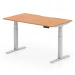 This photograph features a sleek and modern office desk with a scalloped edge oak top and silver adjustable legs. The desks size is 1400x800mm and it offers dynamic sit-stand and height adjustability for maximum comfort and productivity.