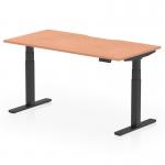 The photograph depicts a sleek and modern dynamic sit stand and height adjustable desk. The desk is 1600 x 800mm in size with a scalloped edge and is made of beech top with black legs. It exudes a professional and functional aesthetic, perfect for any office space.
