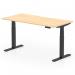 The image shows a sleek, modern office desk with a scalloped edge maple top and black adjustable legs. The desk is set in a standing position, demonstrating its dynamic sit stand capability. The height can be easily adjusted to fit the users needs.