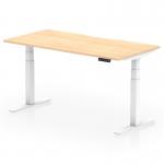 A photo of this dynamic sit stand and height adjustable desk shows a spacious 1600 x 800mm maple top with a scalloped edge, supported by sleek white legs. The desk is easily adjustable to suit any workspace needs and promotes a healthy and ergonomic work environment.