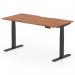 This photograph features a sleek and modern Dynamic Sit Stand and Height Adjustable Desk. The desk size is 1600 x 800mm with a scalloped edge design. The top is made of walnut while the legs are sleek black. The desk is fully height adjustable, making it perfect for any office space.