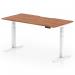 The image shows a sleek and modern sit-stand desk, measuring 1600 x 800mm, with a scalloped edge walnut top and white legs. The height of the desk is adjustable, allowing for customizable comfort and ergonomics in any office space.