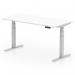 This photograph shows a sleek and modern white top desk with a scalloped edge design. The desk features a silver leg and is height adjustable, allowing for both sitting and standing positions. Its compact size of 1600 x 800mm makes it perfect for any office space.