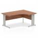 The photograph shows a modern workspace featuring a sleek walnut top with a curved right crescent design. The silver cable managed leg adds a touch of sophistication while maintaining a clutter-free workspace. These dynamic corner desks are perfect for any professional setting.