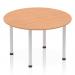 The photograph shows a modern Dynamic Round Tables Impulse 1200mm round table. The table features an oak top and silver post leg, creating a sleek and stylish look. Perfect for any office or meeting space.