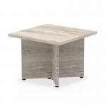 This photo features a sleek and modern Dynamic Tables Impulse 600mm Coffee Table with a grey top. The unique arrowhead leg adds a touch of sophistication and style to any living space.