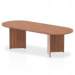This picture features a sleek and modern dynamic boardroom with a 2400mm impulse walnut top boardroom table. The table is supported by arrowhead legs, adding a touch of sophistication to the overall look.