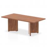 The photo features a stylish, modern coffee table with a rich walnut top and sleek arrowhead legs. Its dynamic design adds a touch of sophistication to any living space.