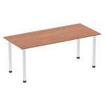 In the photo, a 1800mm straight table with a walnut top and chrome post leg is seen. The table has a sleek and modern design, with a dynamic and versatile feel. The walnut adds warmth and character, while the chrome post leg adds a touch of sophistication. This table is the perfect addition to any modern workspace.