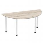 The image shows a sleek and stylish dynamic table with a semi-circle grey oak top and chrome post leg. The table appears to be 1600mm in size, making it perfect for a modern office or workspace. The semi-circle shape adds a touch of uniqueness to the overall design.