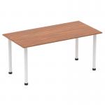 The photo shows a sleek and modern Dynamic Tables Impulse 1600mm straight table with a rich walnut wood top and sharp white post legs. The clean lines and contrasting tones create a stylish and dynamic workspace.