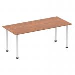 In this picture, a sleek and modern Dynamic Tables Impulse 1800mm Straight Table is shown with a rich walnut top and contrasting white post legs. The dynamic design creates an aesthetic focal point and provides ample workspace for organization and productivity.