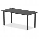 The picture shows a sleek black straight table from the Dynamic Tables Impulse Black Series. It features a 1600 x 800mm black top with integrated cable ports and stylish black post legs.