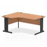 In the photo, the dynamic left hand desk appears as a sleek and modern piece of office furniture. The oak top and black cable managed leg offer a sophisticated contrast, while the curved left crescent shape adds visual interest. The desk is organized and ready for productivity.