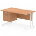 This photograph showcases a sleek, modern Dynamic Pedestal Desk Impulse, measuring 1400 x 800mm, with a scalloped edge and straight design. The desk features an oak top and white cantilever legs, providing a stylish and functional workstation. The desk also includes a fixed pedestal with 2 drawers, adding additional storage space.