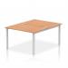 This photo features a dynamic bench desking setup with two workstation spaces, each with a silver frame and oak desk surface. The sleek, modern design and sturdy construction make it perfect for any office environment.