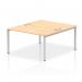 The photograph captures an open office space with a sleek and modern dynamic bench desking set-up. The two-person Impulse Bench B2B is shown with a silver frame and a spacious maple top. The clean and functional design is perfect for collaboration and productivity.