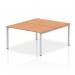 This photo features a sleek and modern bench desk with a silver frame and oak top. The dynamic design allows for two individuals to work comfortably, making it a great addition to any office space.