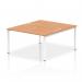 The photo showcases a dynamic bench desking system, specifically the Impulse Bench B2B for two people. The desk is 1400 inches in length with a sleek white frame, paired with a stunning oak top. Its simple yet modern design is perfect for any office space.