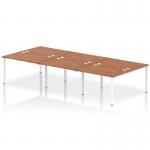 This photograph captures a sleek and modern design, featuring a dynamic bench desk with a white frame and a walnut finish. The spacious 6-person setup allows for collaborative working, while the clean lines and minimalist look add a touch of sophistication to any office space.