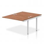 This photo showcases a sleek and modern dynamic bench desking set-up, featuring the Impulse Bench B2B Ext Kit in a sleek silver frame. The spacious desk is made with a rich walnut finish, creating a professional and stylish look for any office.