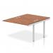 This photo showcases a sleek and modern dynamic bench desking set-up, featuring the Impulse Bench B2B Ext Kit in a sleek silver frame. The spacious desk is made with a rich walnut finish, creating a professional and stylish look for any office.