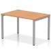 This picture features a stylish and modern Dynamic Bench Desking Impulse Bench Office Desk in a single row design with a sleek silver frame and a beautiful oak finish. The clean lines and functional design make this desk a versatile addition to any office space.