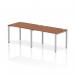 This photograph captures a sleek and modern office space featuring a dynamic bench desking system. The impulse bench, with a silver frame and walnut desk, accommodates two people in a single row. The design is both functional and stylish, perfect for any contemporary workplace.