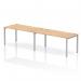 The photograph features a sleek and modern office set-up, with a single row of dynamic bench desks. The silver frame adds a touch of sophistication, while the maple wood finish brings warmth to the space. The desk comfortably fits two people, making it a great option for collaborative work.