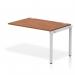This picture features a sleek, modern bench desk with a silver frame and walnut top. The single row extension kit adds flexibility to the design, making this dynamic bench desking system perfect for any office setting.