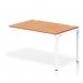 The picture shows a sleek and modern bench desk with a white frame and an oak desk surface. The single row extension kit adds versatility and functionality to the dynamic bench desking set-up. Perfect for any office space looking for a stylish and efficient work area.