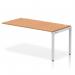 The image shows a sleek, modern bench desk with a silver frame and oak top. The desk is part of a single row extension kit, creating a dynamic workspace for any office.