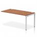 The photo shows a sleek and modern Dynamic Bench Desking Impulse Bench, with a single row extension kit measuring 1600. The silver frame complements the dark walnut desk, giving it a professional and stylish look. Perfect for any office setting.