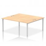 This image features a sleek and modern dynamic bench desking setup. The Impulse Bench B2B includes two spacious workstations with a 1800 silver frame for stability. The office bench desk is topped with a maple finish for a touch of warmth.