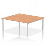 This photo shows a modern and sleek dynamic bench desk with two workspaces, each 1800mm in length. The silver frame gives it a contemporary look while the oak finish adds warmth. Perfect for a professional office setting.