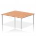 This photo shows a modern and sleek dynamic bench desk with two workspaces, each 1800mm in length. The silver frame gives it a contemporary look while the oak finish adds warmth. Perfect for a professional office setting.