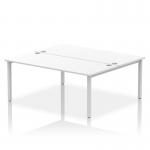 The picture shows a modern and sleek Dynamic Bench Desking Impulse Bench B2B with a silver frame and a white desk surface. The spacious 1800 design allows two people to work comfortably side by side. This office bench desk offers a dynamic and efficient workspace for any office setting.