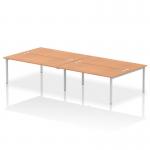 This picture features a sleek and modern office setup with a dynamic bench desking system. The Impulse Bench B2B accommodates four people and has a silver frame and an oak desk.