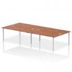 This image features a sleek and modern dynamic bench desking system, with a silver frame and a beautiful walnut finish. It can accommodate four people and measures 1800 in length. Perfect for any professional office setting.