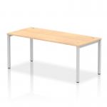 This photograph captures a sleek and modern office space featuring a dynamic bench desking set-up. The silver frame of the Impulse Bench Single Row 1800 is complemented by the maple desk top, creating a visually appealing and functional workspace.