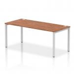 The Dynamic Bench Desking Impulse Bench features a sleek silver frame and a single row with a length of 1800. The office bench desk has a modern walnut finish, adding a touch of sophistication to any workspace.