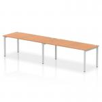 The photo displays a dynamic bench desking setup, featuring a single row layout for 2 people. The silver frame adds a modern touch, while the oak desk surface creates a warm and inviting workspace. The Impulse series offers practical yet stylish office solutions.