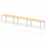 In this photograph, we see a stylish and modern Dynamic Bench Desking Impulse Bench. It features a single row, with enough space for 3 people, all sitting comfortably at the 1800 Silver Frame Office Bench Desk. The desk is finished in a beautiful Maple color, creating a clean and professional look.