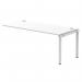 The picture shows a modern and versatile office bench, the Dynamic Bench Desking Impulse Bench Single Row Ext Kit 1800 in a sleek silver frame. The spacious white desk easily accommodates multiple users, making it perfect for a busy and dynamic workspace.